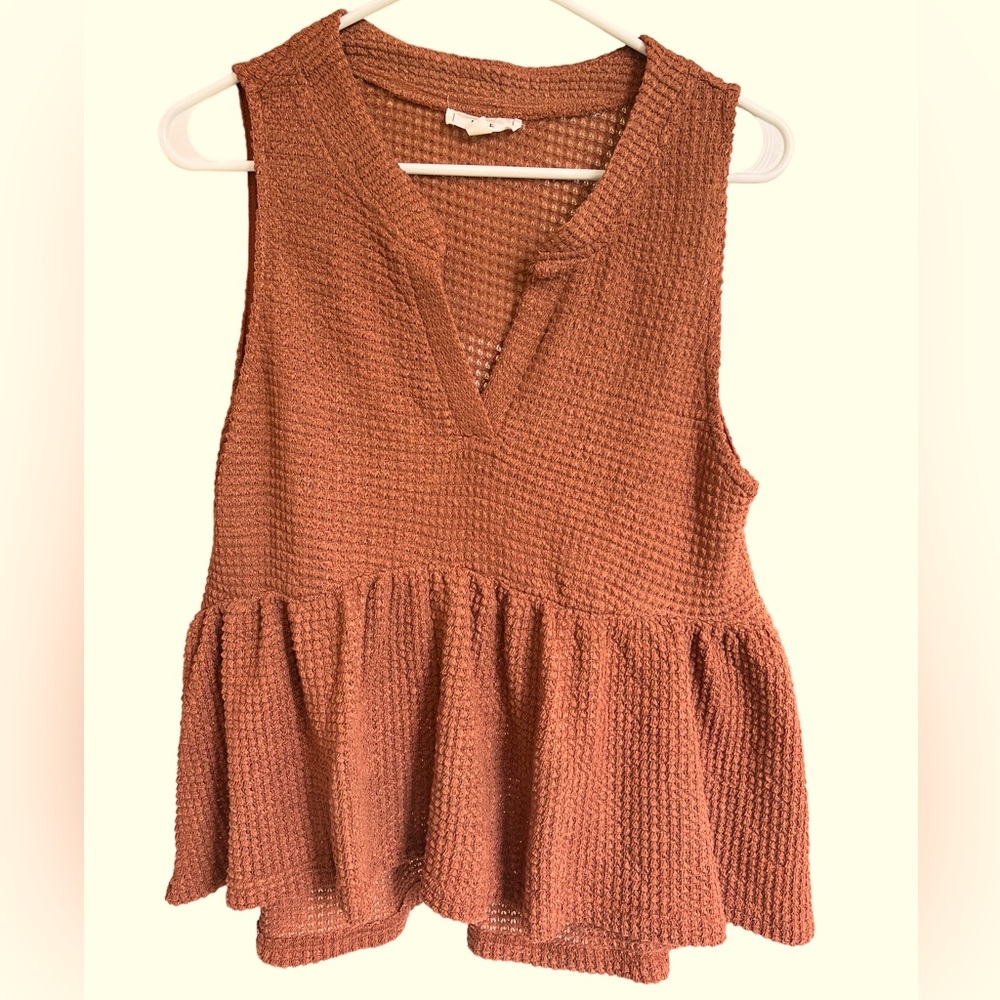 Burnt orange waffle knit summer top with ruffle bottom.